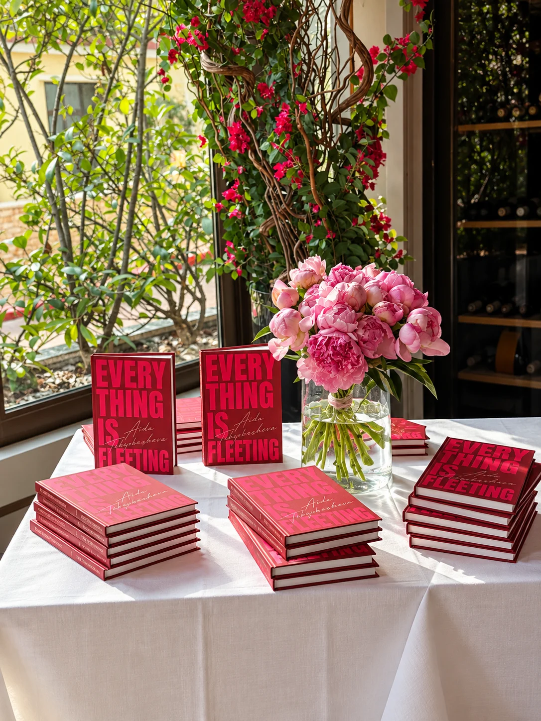 Everything Is Fleeting poetry books by Aida Takyrbasheva with pink peonies